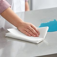 a person wiping up some white paper on a table