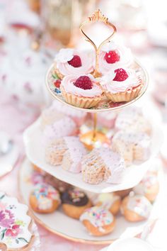 three tiered trays filled with cupcakes and pastries