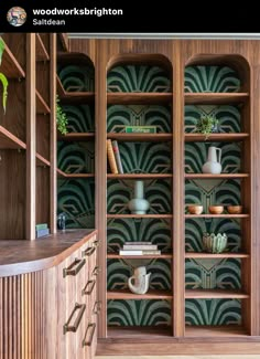 a wooden bookcase filled with lots of books next to a wall mounted planter