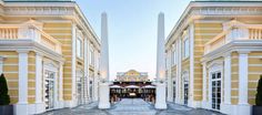 an empty walkway between two buildings with columns on each side and pillars in the middle