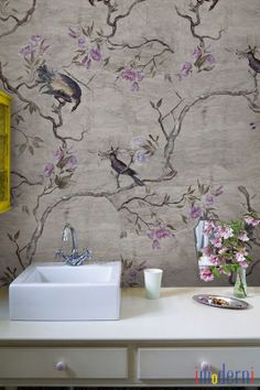 a white sink sitting under a mirror next to a wall mounted faucet in a bathroom