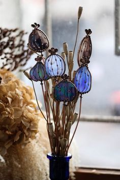 a blue vase filled with lots of glass flowers