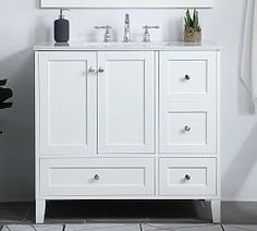 a white bathroom vanity with two sinks and a large mirror above it, next to a potted plant