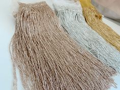 three different colors of tassels on a white surface