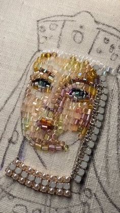 a close up of a piece of art with beads on the bottom and an image of a woman's face