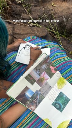 a woman with green hair sitting on top of a colorful blanket holding a piece of paper