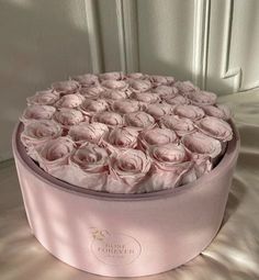 a pink hat box filled with lots of roses