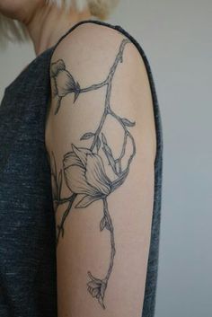 a woman with a flower tattoo on her arm