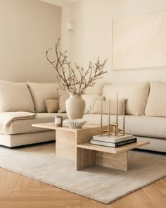 a living room with a couch, coffee table and vase on top of the table