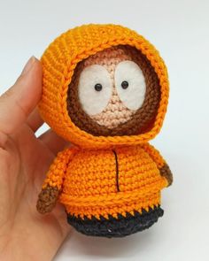 a crocheted stuffed animal wearing an orange jacket