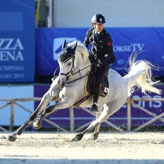 a woman riding on the back of a white horse