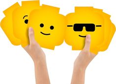 two hands holding up yellow smiley faces with sunglasses on them, and the other hand is pointing