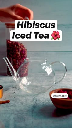 a glass tea pot sitting on top of a table next to a bowl filled with liquid