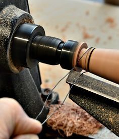 a person is working on some kind of object with a large metal piece in front of them