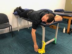 a man laying on top of a table with a yellow object in front of him