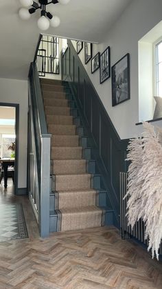 a staircase with pictures on the wall next to it and a rug in front of it