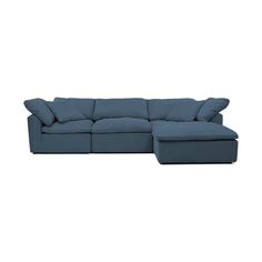 a blue sectional couch with pillows on the top and bottom corner, facing away from the camera