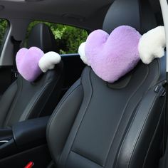 two purple and white heart shaped pillows in the back seat of a car