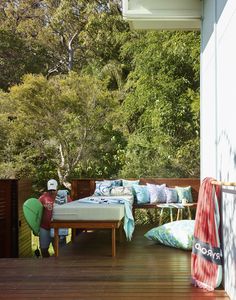 a bed sitting on top of a wooden floor next to a lush green forest