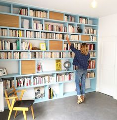 a child is reaching up to reach the bookshelf