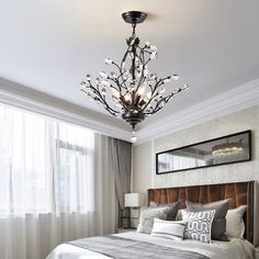 a bed room with a neatly made bed and a chandelier hanging from the ceiling