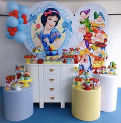 snow white and the seven dwarfs themed birthday party set up with balloons, decorations, and tableware