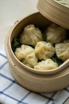 some dumplings are in a wooden container on a table