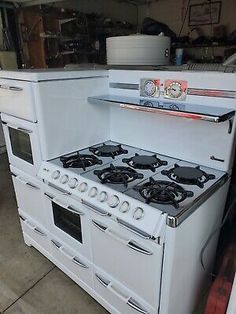 an old white stove and oven in a garage