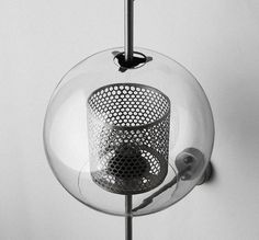 a black and white photo of a glass ball hanging from a hook on a wall