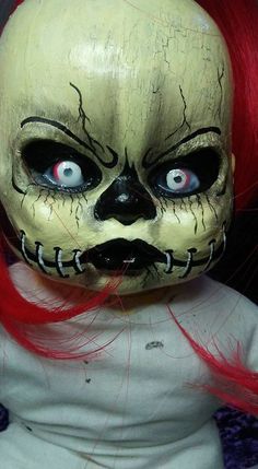 a creepy doll with red hair and blue eyes