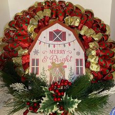 a merry and bright christmas wreath with holly, pine cones, candy canes and a barn