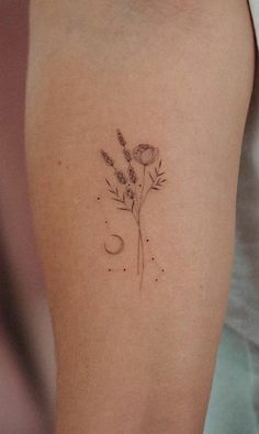 a woman's arm with a flower and moon tattoo on the left side of her arm