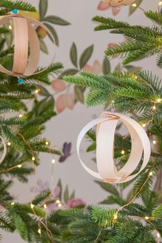 the christmas tree is decorated with ribbon and ornaments, including two ornament hanging from it's branches