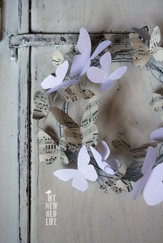 a wreath made out of sheet music and paper butterflies