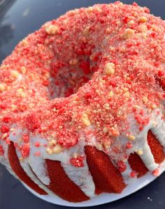 a red velvet bunt cake with white frosting and sprinkles