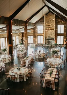 an indoor venue with tables and chairs set up for a wedding reception at the lodge