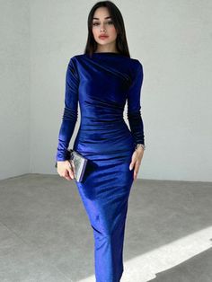 a woman in a blue dress posing for the camera with her hand on her hip