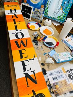 the table is covered with halloween decorations and art supplies for kids to make their own pumpkins