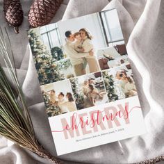 a christmas card on top of a white blanket next to pine cones and evergreen needles