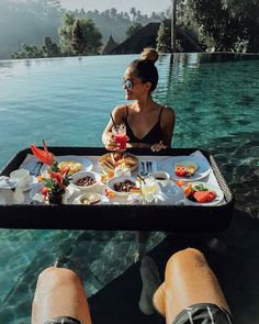 a woman sitting at a table with food in front of her on instagram page