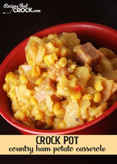 a red bowl filled with corn and meat on top of a wooden table next to a black background