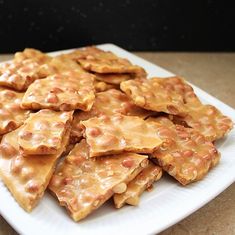 a white plate topped with cheesy crackers on top of a table