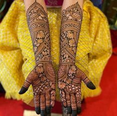 two hands with henna designs on them