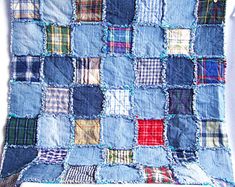 a blue patchwork quilt is hanging on the wall