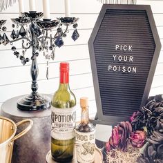 a table topped with bottles of alcohol next to a chandelier and vases