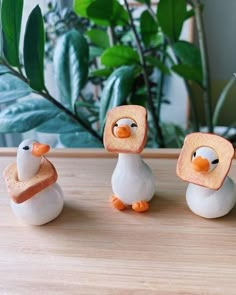 three small figurines made to look like ducks with bread slices on their heads