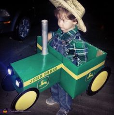 a young boy in a green tractor costume