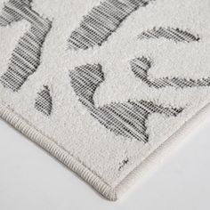 a white rug with black and grey designs on it