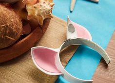 a pair of scissors sitting on top of a wooden bowl filled with coconuts and other fruit