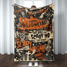 a person holding up a halloween themed blanket